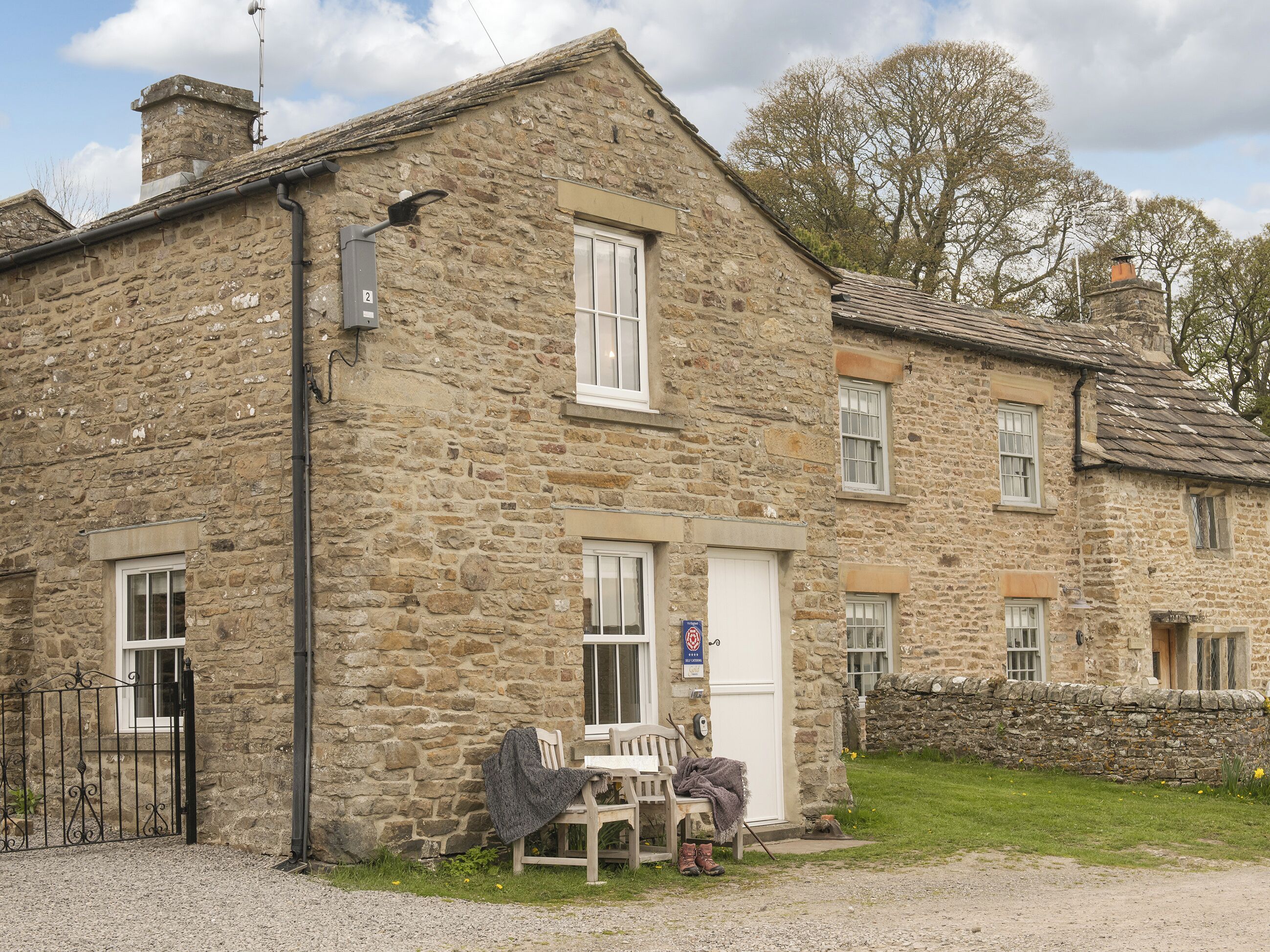 A stone building with a traditional design, featuring a small porch with a bench and a door.