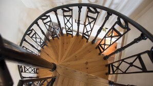 A wooden spiral staircase with black metal railings.