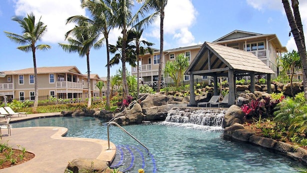 Un resort con piscina, una cascada y un pabellón cubierto.