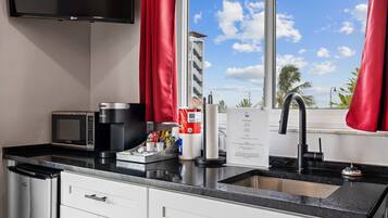 A modern kitchen with a microwave, coffee maker, and paper towel dispenser.