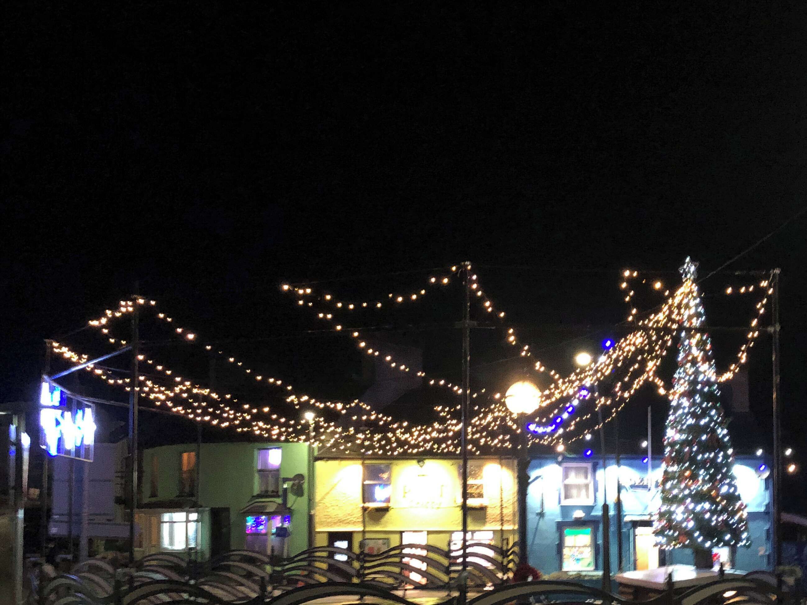 Ein Gebäude mit Weihnachtsbaum und Lichterkette.