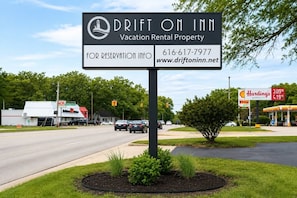 A sign for Drift on Inn, a vacation rental property, with contact information and a website. - Modern Boutique Queen Studio | Near Downtown Muskegon (Muskegon)