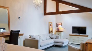 A bedroom with a bed, a sofa, a TV, a desk, and a chandelier. - 1 bedroom accommodation in Clappersgate, near Ambleside (Clappersgate, near Ambleside)