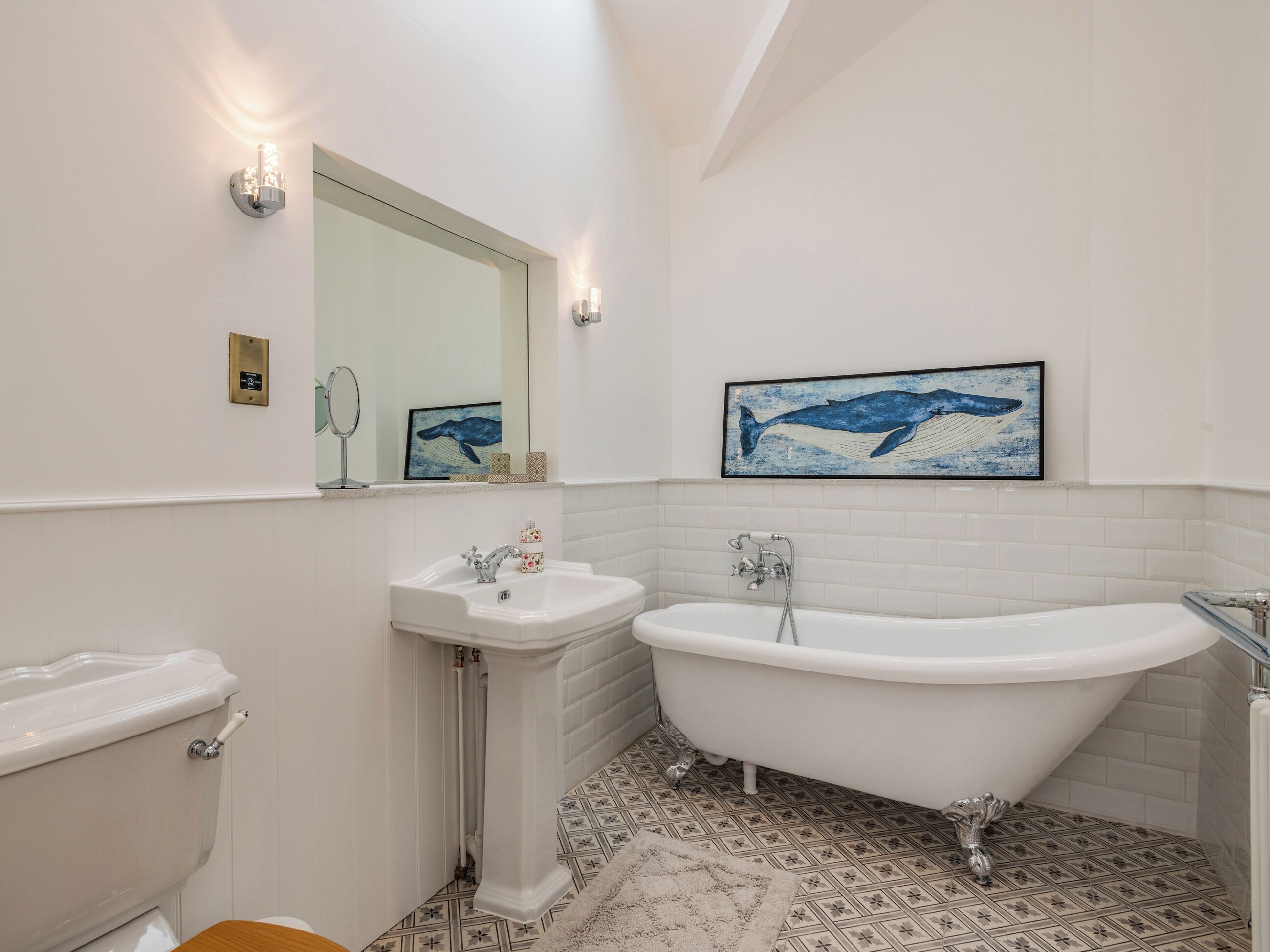 A bathroom with a toilet, sink, and freestanding bathtub.