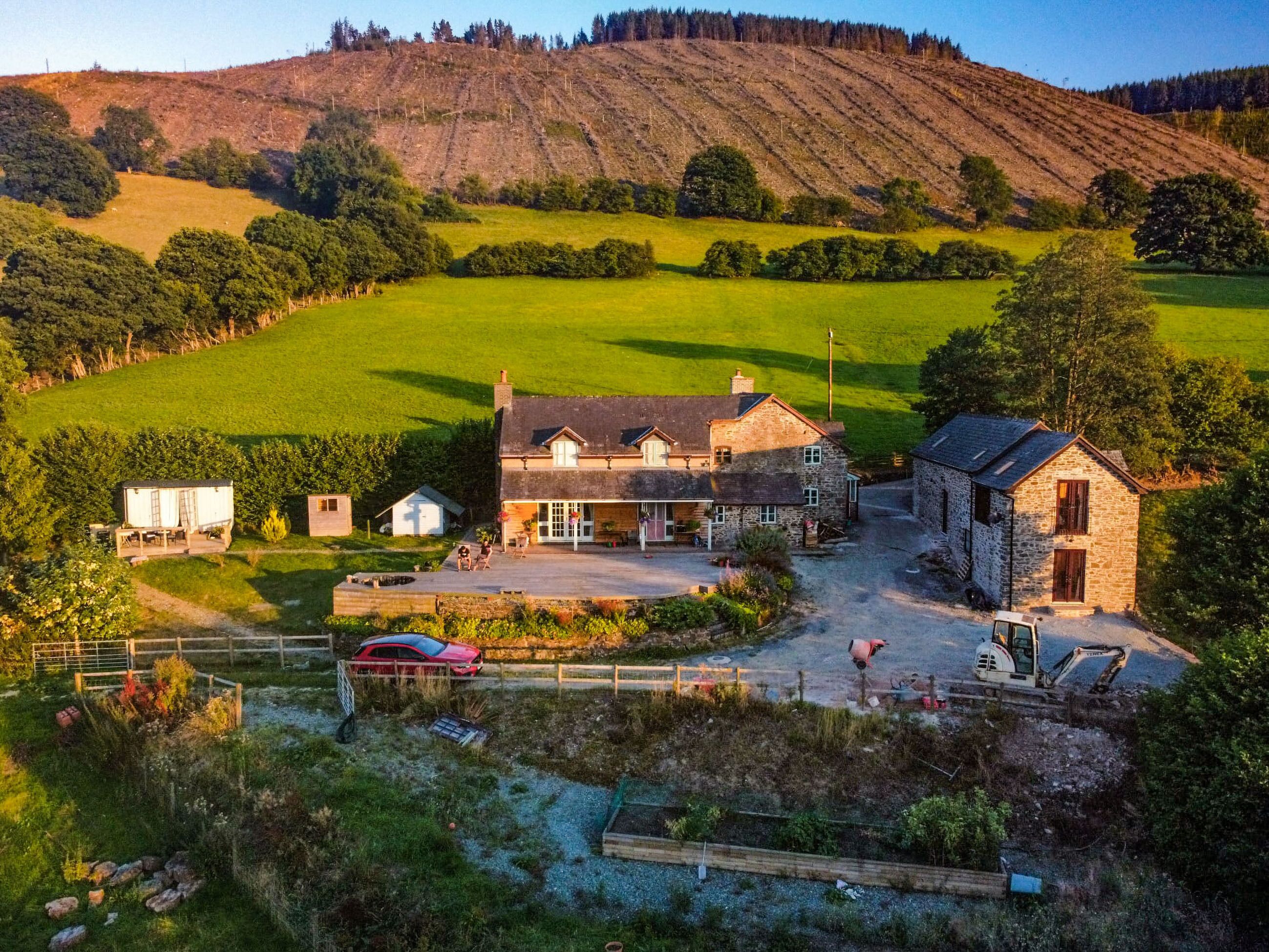 A large stone house with a spacious driveway and a fenced yard.