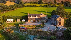 A large stone house with a spacious driveway and a fenced yard. - 2 bedroom accommodation in Penybntfawr, near Oswestry (Penybntfawr, near Oswestry)