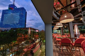 A modern building with a glass facade and a rooftop structure.