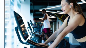 A gym with treadmills and a person using one.