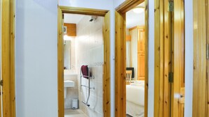 A hallway leading to a bathroom with a shower, a sink, and a toilet. - Quaysiders Club B - UK34758 (Ambleside)