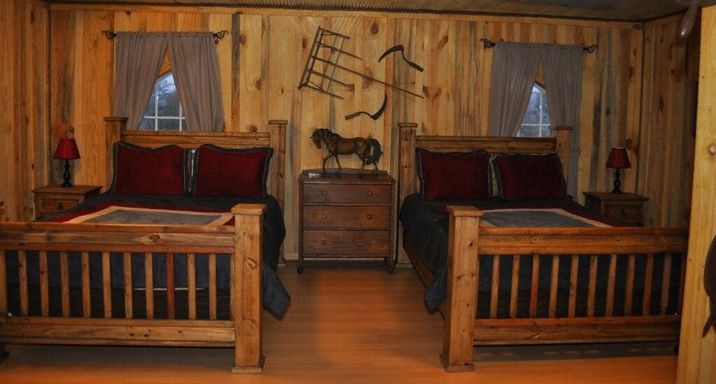 A wooden cabin-style room with two beds, a dresser, and a horse figurine on the wall.
