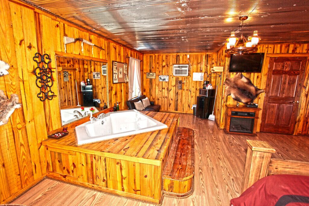 Un intérieur en bois avec une grande baignoire, un téléviseur et une cheminée.