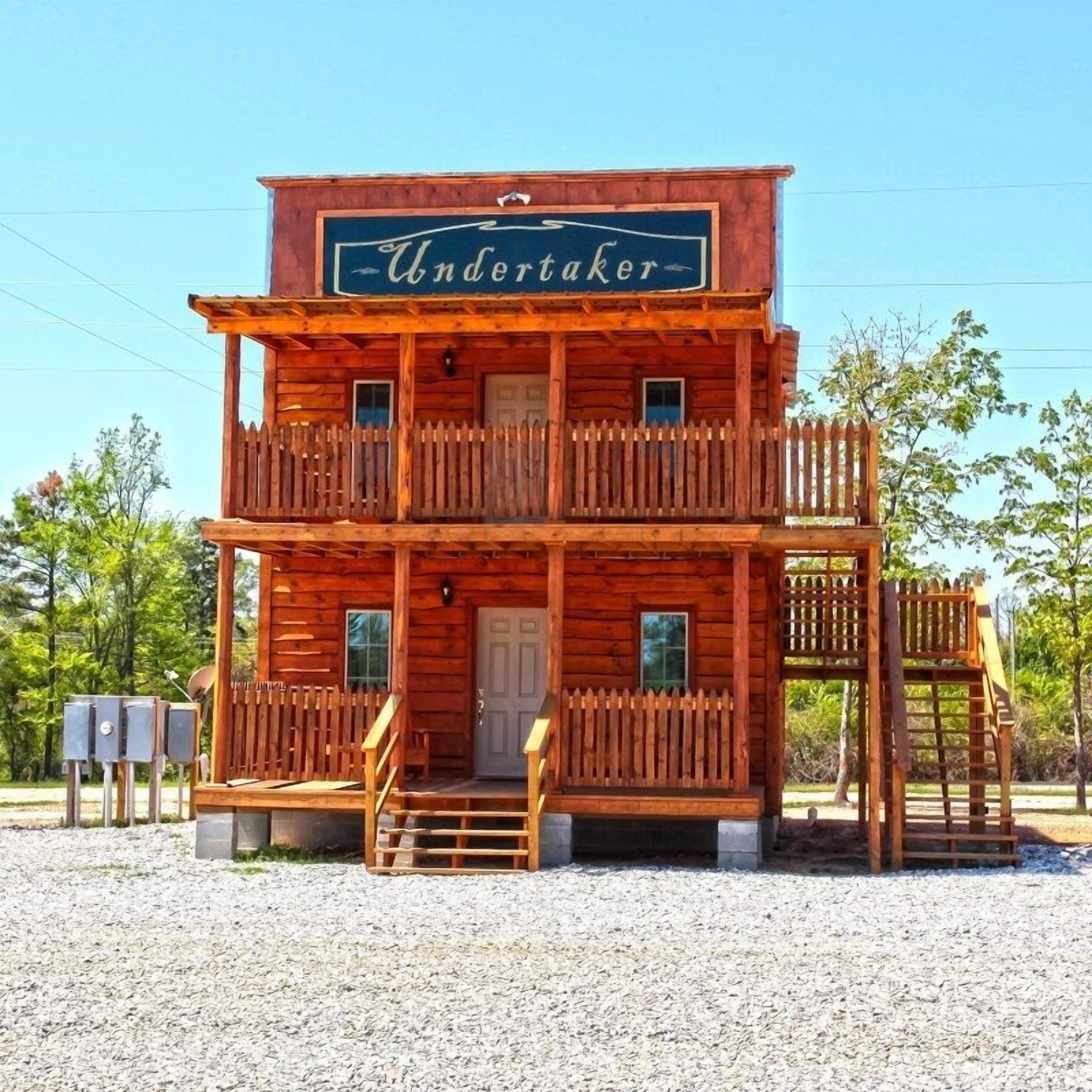 A wooden building with a sign reading "Undertaker" and a balcony.