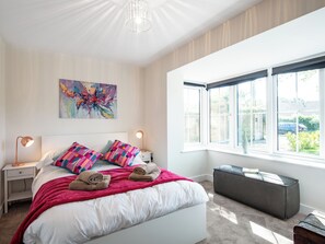 A bedroom with a bed, two bedside lamps, a window, a painting, and a bench. - 5 bedroom accommodation in Everton (Everton)
