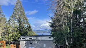 Une maison avec un garage, entourée d’arbres et offrant une vue sur un lac.