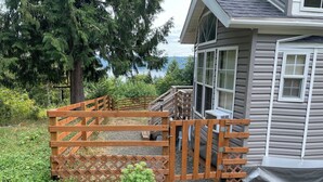 Une porte en bois qui mène à une maison offrant une vue sur un lac et des arbres.