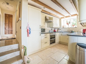 A kitchen with white cabinets, a stove, and a sink.