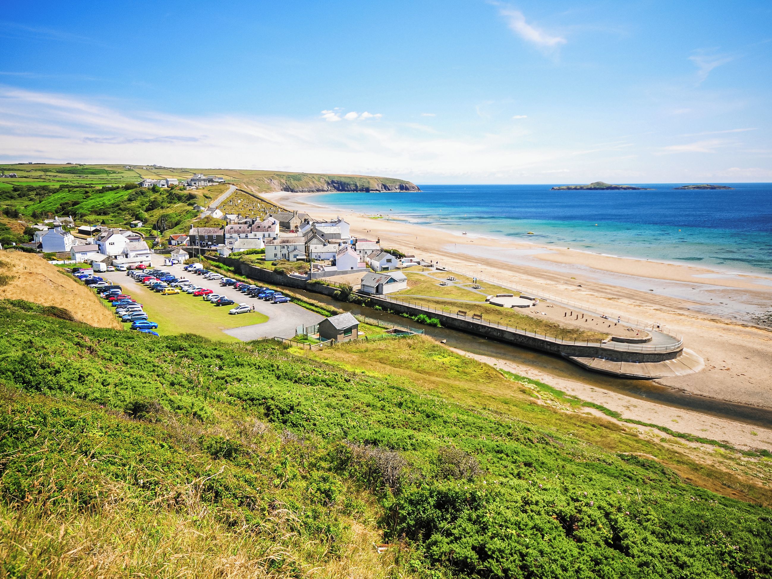 Une ville côtière dotée d’un port de plaisance, d’une plage et de maisons.
