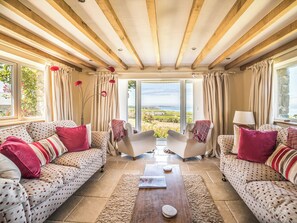 A room with two sofas, a coffee table, and a view of the outdoors.