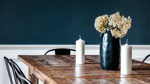 Et træspisebord med en vase blomster og stearinlys.