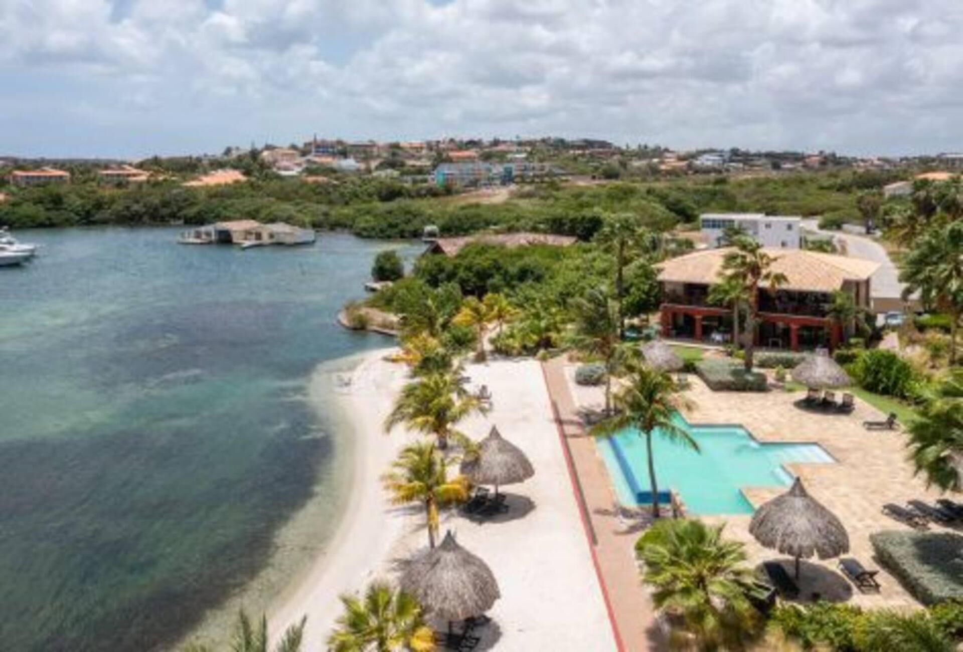 A resort with a pool, beach, and ocean view.