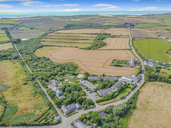 An aerial view of a rural area with fields, a small village, and a body of water.