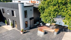 A modern building with a flat roof, a sign for 'Handling Market', and a tree in front. - Private King Studio Close to the Action and Recently Renovated (Muskegon)
