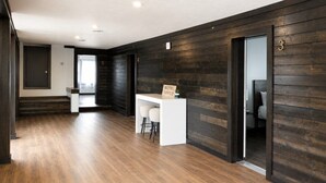 Eine Hotelhalle mit einer Rezeption, einer Treppe und einer dunklen Holzwand.