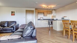 A modern apartment with a living room, kitchen, and dining area.