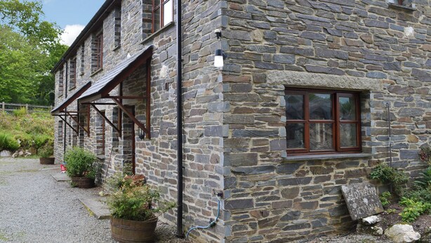 A stone building with a wooden porch and a window.