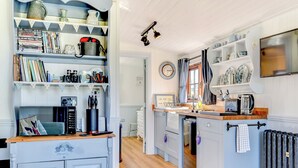 A kitchen with a central island, wooden cabinets, and a variety of kitchen appliances.
