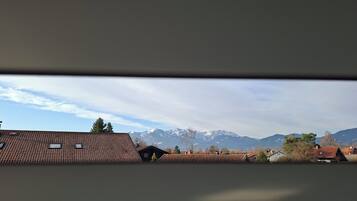 A view of a residential area with houses, a mountain range, and a clear sky.