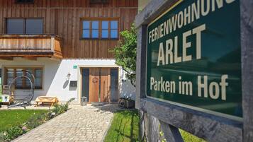 En træbygning med et skilt, der siger 'FERIENWOHNUNG ARLET Parken im Hof'.