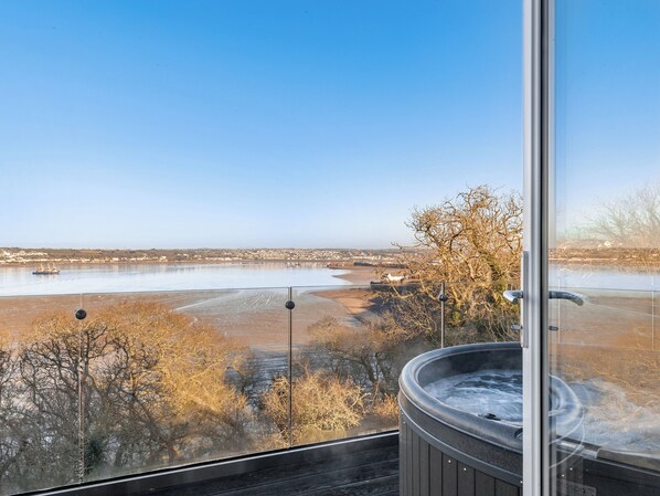 Un jacuzzi con vistas a un lago helado y un paisaje urbano.