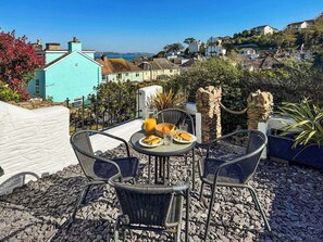 Una terrazza con tavolo apparecchiato per la colazione, con vista su una località costiera.