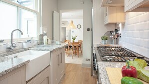 A modern kitchen with granite countertops, stainless steel appliances, and wooden cabinetry. - 2 bedroom accommodation in Brixham (Brixham)