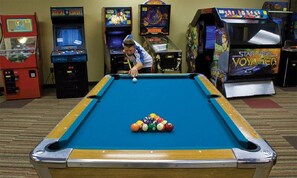 Enjoy a game of pool or challenge friends to a round of classic arcade games in this entertainment room.