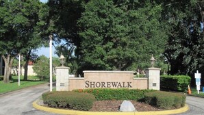 A sign for Shorewalk with a landscaped area and trees in the background. - Remodeled, Luxurious 2BR+2Bath by IMG+Beach (Bradenton)
