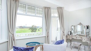 A room with a view of a bridge, a vanity with a mirror, and two chairs with cushions. - 5 bedroom accommodation in Paignton (Paignton)