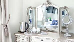 A white vanity with a mirror, a kettle, and a tray with toiletries. - 5 bedroom accommodation in Paignton (Paignton)