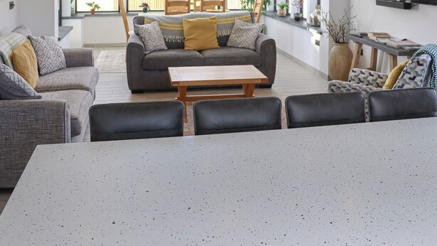Una sala de estar con un sofá, sillas, una mesa de centro y un televisor.