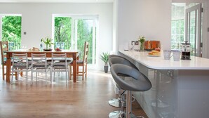 Une cuisine moderne dotée d’un grand îlot central, d’une table à manger en bois et de chaises.