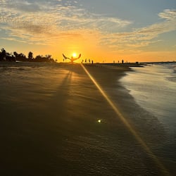 Guests can enjoy a serene beach experience with calm waters and soft sand.