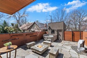A backyard with a stone fire pit, outdoor seating, and a barbecue grill. - Lux Home w/ Hot Tub+Fire Pit steps from Hyde Park (Boise)