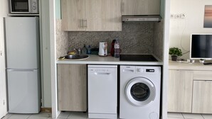 A compact kitchen with a microwave, sink, and dishwasher. - Ideally located 4-person apartment with exceptional view (Saint-Raphaël)