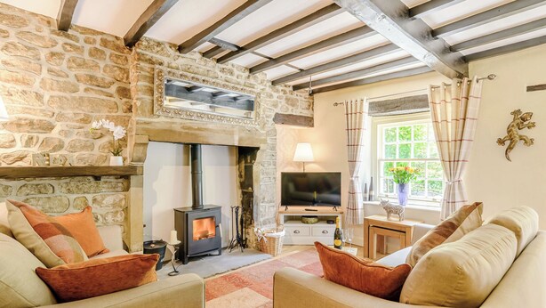 A cozy living room with a stone fireplace, wooden beams, a television, and comfortable seating. - 3 bedroom accommodation in Bewerley, near Pateley Bridge (Bewerley, near Pateley Bridge)