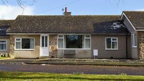 A two-story house with a stone facade, a tiled roof, and a small front porch. - 3 bedroom accommodation in Newton by the Sea (Newton by the Sea)