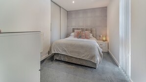 A bedroom with a bed, a nightstand, a radiator, and a window with blinds. - 3 Ladyknowe - UK39969 (Moffat)