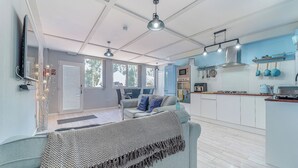 A modern kitchen with a built-in oven, microwave, and stove. There is a dining area with a table and chairs, and a large window providing natural light. - 3 Ladyknowe - UK39969 (Moffat)