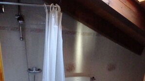 A small bathroom with a shower, toilet, and bidet.