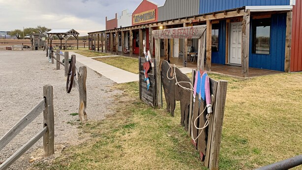 A rustic building with a wooden porch and a sign reading "AZZY BULLDOGS."